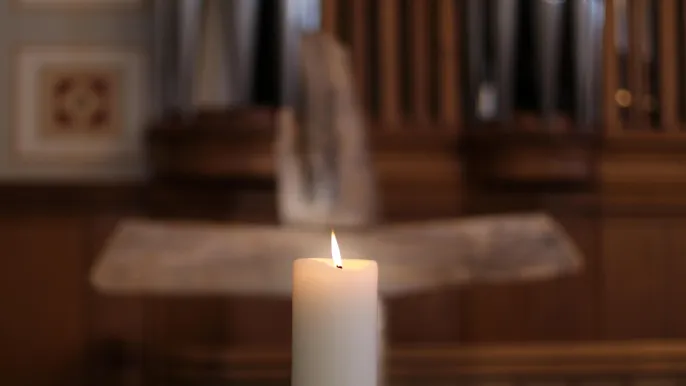 Kerze mit Kreuz im Hintergrund (Foto: Sekretariat )